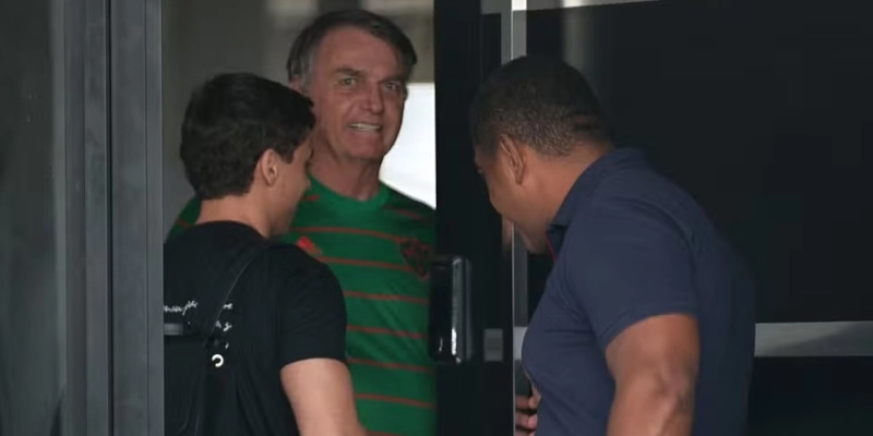 O ex-presidente do Brasil, Jair Bolsonaro, aparece na porta de sua casa, durante sua prisão domiciliar, em Brasília, Brasil, em 21 de novembro - Mateus Bonomi/Reuters