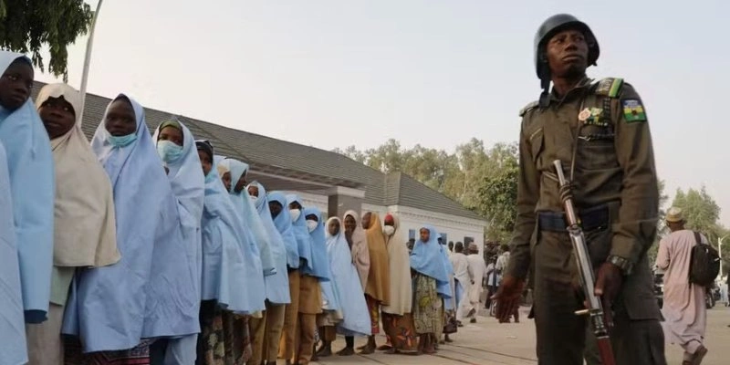 Soldado vigia junto a grupo de estudantes libertadas após sequestro em escola por jihadistas no norte da Nigéria em 2021 - AFP